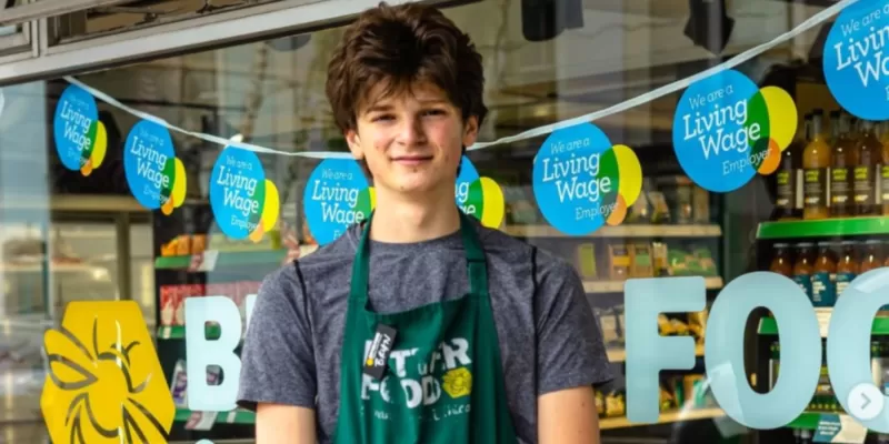 Better foods employee with Living Wage bunting in shop window